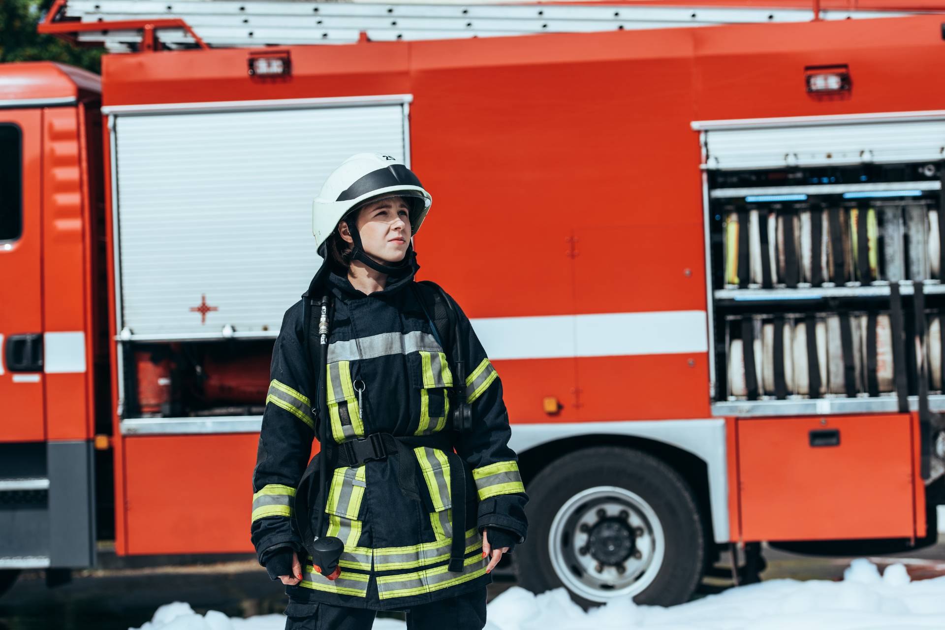 First responder in uniform standing in front of a firetruck