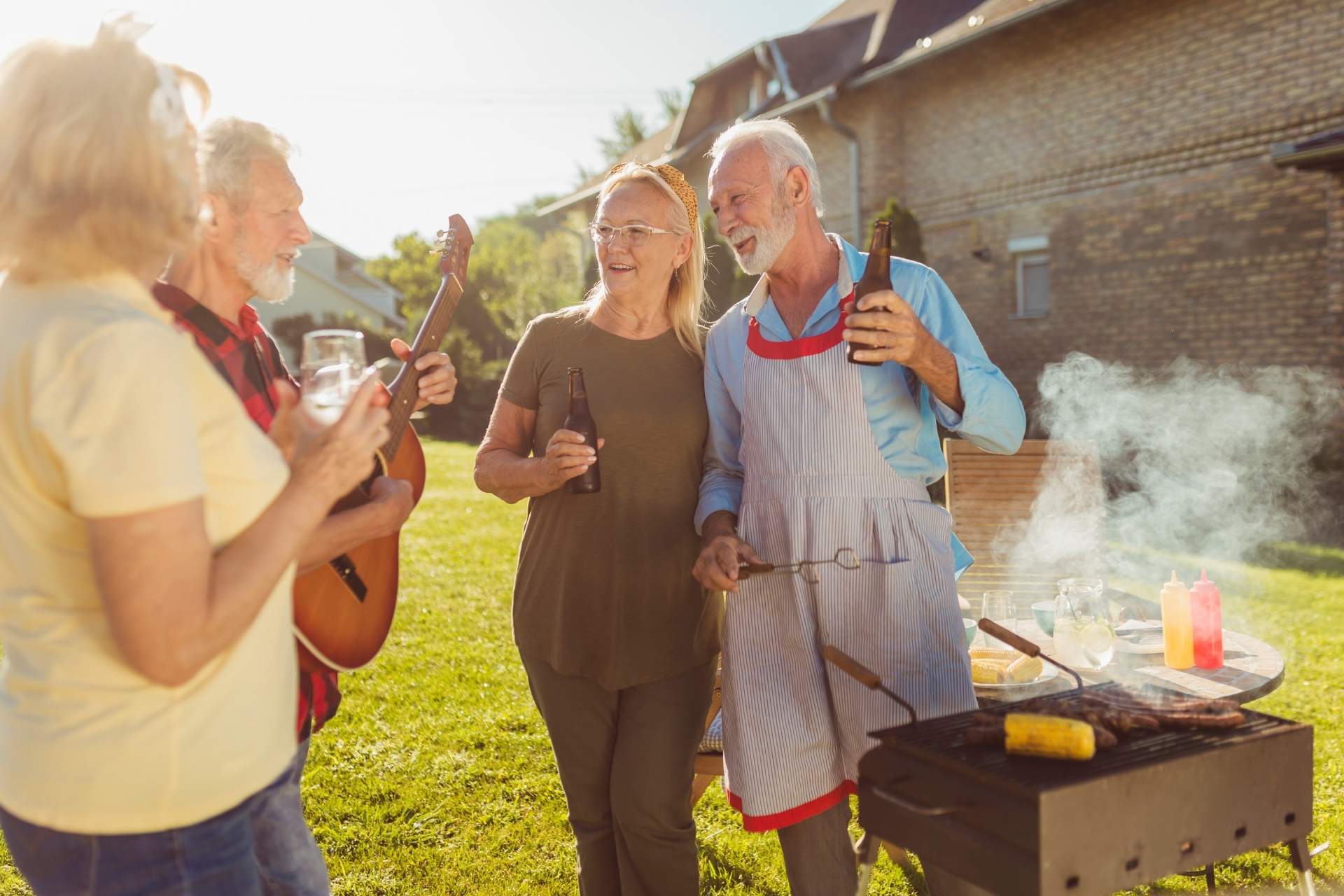 A group of seniors standing outside enjoying a BBQ.